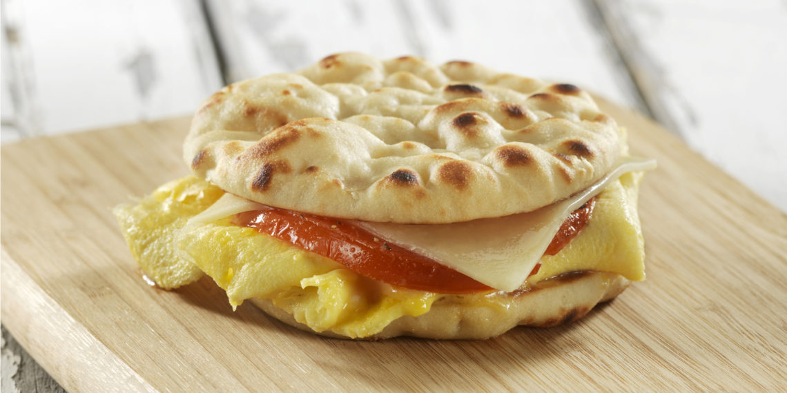 An easy and quick egg, cheese and tomato breakfast sandwich made with Stonefire Original Naan Rounds