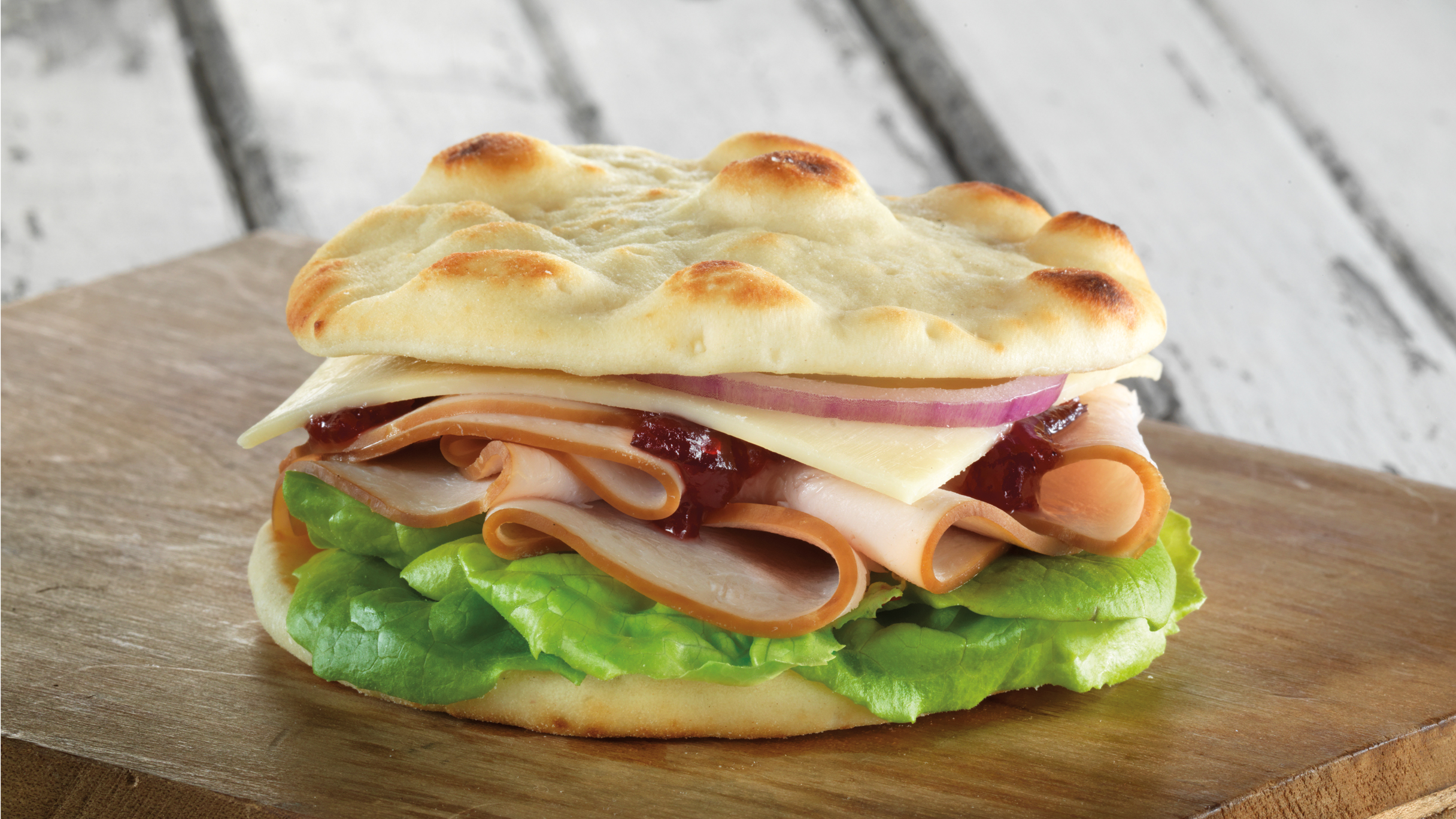An easy and quick turkey, cranberry cheese and onion sandwich made with Stonefire Original Naan Rounds